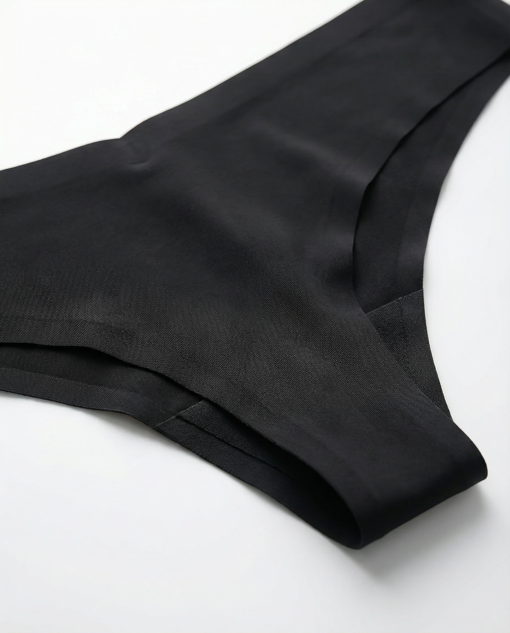 Close-up rear angle view of the LOAR black seamless thong, highlighting the smooth, invisible fabric edges. Premium activewear.