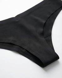 Close-up rear angle view of the LOAR black seamless thong, highlighting the smooth, invisible fabric edges. Premium activewear.