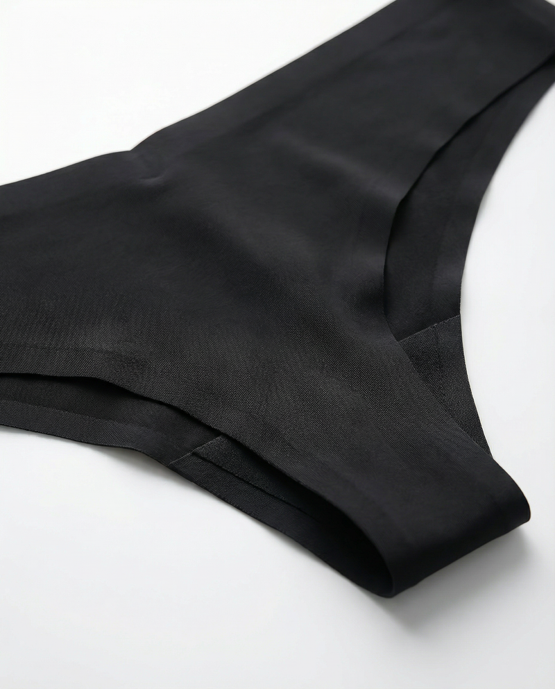Close-up rear angle view of the LOAR black seamless thong, highlighting the smooth, invisible fabric edges. Premium activewear.