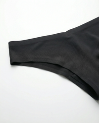 Close-up side profile view of the LOAR black seamless thong, highlighting the invisible edge design. Premium alternative activewear